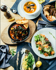 Various dishes of seafood and salads on the served table. Family holiday table. Set of different delicious dishes on the table top view