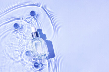 Mockup of cosmetic glass blue bottle with pipette and serum on water surface with waves