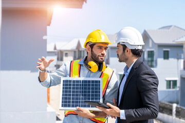 Engineers with Businessmen discussing and checking solar cell for residential under construction.