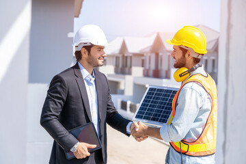 Close up businessman and engineers shaking hands after discussing install solar panels on houses...