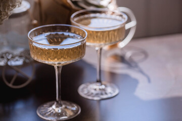 A bouquet of white hydrangeas and pink astilba, succulent, candles and a fashionable glass for dessert and champagne with wine inside. Cozy interior. The concept of a party, wedding and holiday.