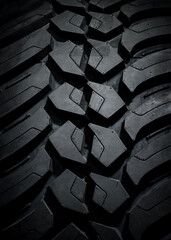 new tire for off-road and off-road vehicles and crossovers on a black background. vertical.