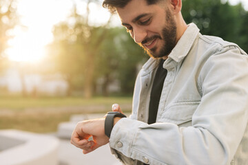 Smartwatch on a man's hand outdoor. Man's hand touching a smart watch. Closeup shot of male's hand...