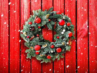 Christmas wreath on the background of a wooden wall. A wreath of Christmas tree branches decorated...