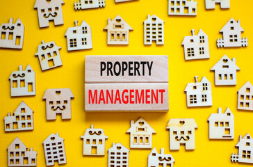 Property management symbol. Concept words Property management on wooden blocks on a beautiful yellow table yellow background. Wooden house model. Business property management concept. Copy space.