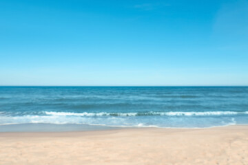 Blurred view of beautiful sea and sandy beach on sunny day