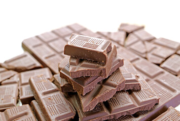 Closeup pile of delectable chocolate chunks on white backdrop