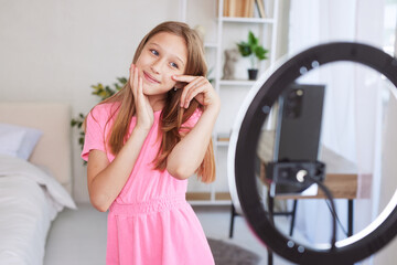 Little Girl Making Video For Blog Via Phone At Home