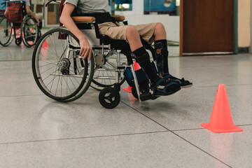 Young man with disability practicing wheelchair by an occupational therapist teacher on ramps for...