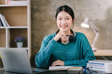 Smart and positive Asian female freelancer or student studying online webinars or courses at home. Video calling and chatting