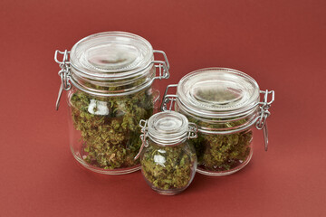 Glass jars of different sizes with marijuana buds