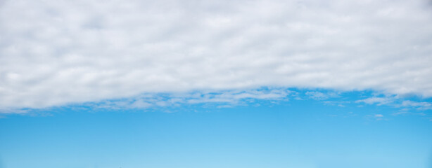 blue sky background with light grey cloud overcast in the upper half