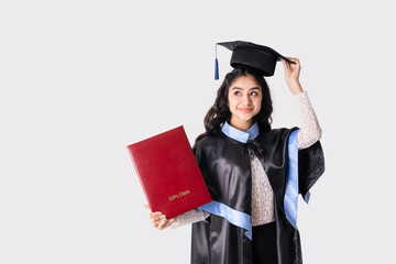 Beautiful indian woman university graduate wearing academic regalia with red diploma mockup...