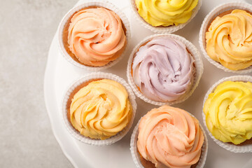 Stand with tasty cupcakes on light table, top view
