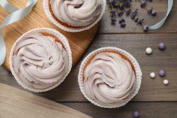 Tasty cupcakes on wooden table, flat lay