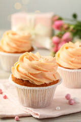 Tasty cupcake with cream on table, closeup view