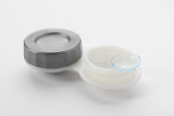 Case with contact lens on white background, closeup