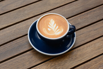 Cup of aromatic coffee on wooden table