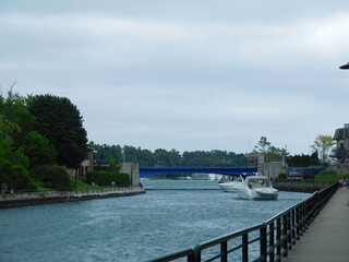 boats aproching blue bridge over river in nothern michigan