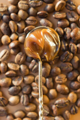 Spoon with caramel sauce coffee beans