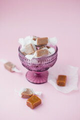Caramel candies in purple glass bowl