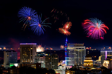 Many fireworks blooming over the Boise skyline at night