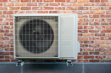 Heat pump air conditioning outdoor unit hanging on wall.