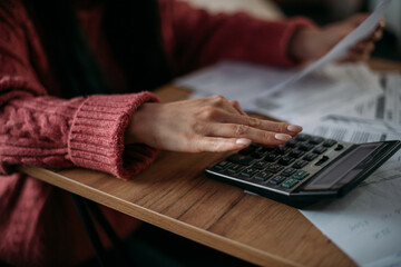 Close-up of woman's hands with calculator and utility bills. The concept of rising prices for...