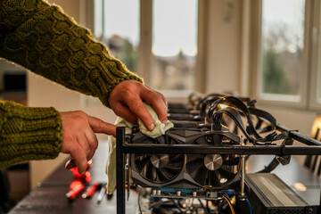 Man wiping cryptocurrency mining rig with rag