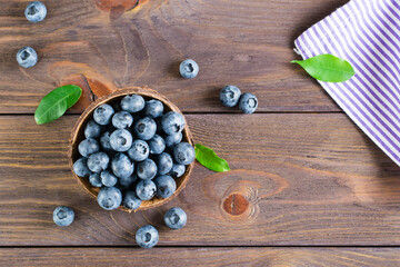 Fresh blueberries in a bowl on a wooden table. Organic Wild Superfood. Top view