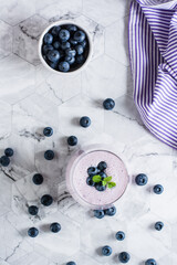 A glass of blueberry smoothie on the table. Antioxidant organic healthy food. Top and vertical view