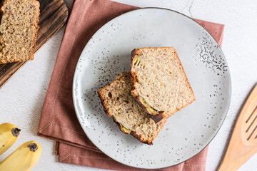 Pieces of banana bread on a plate on the table. Homemade breakfast. Top view. Close-up