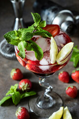 Fresh summer  alcohol cocktail with berries, mint and lime slices in glass