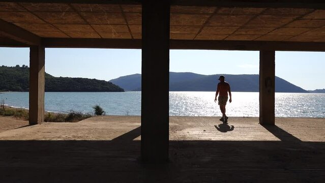 Ksamil, Albania A man walks on a concrete floor in an unfinished building on Lake Butrint. 