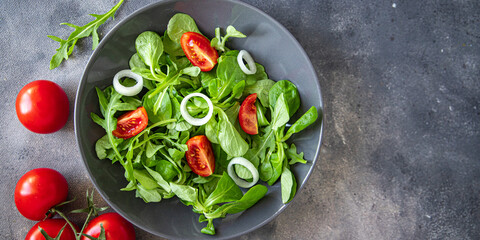 salad vegetable tomato, onion, lettuce mix, mache green fresh healthy meal food snack diet on the table copy space food background rustic top view 