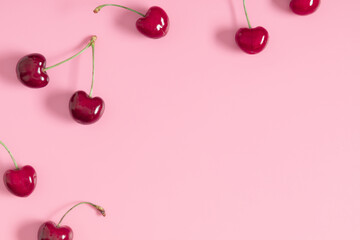 Red cherry on pink background. Ripe red cherry berries as background. Flat lay, top view, copy space