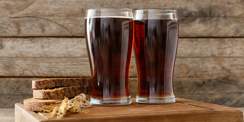 Glasses of cold kvass on wooden background