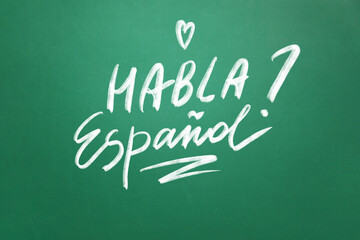 Text HABLA ESPANOL? (DO YOU SPEAK SPANISH?) on school blackboard