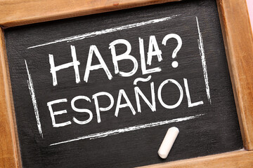 Chalkboard with text HABLA ESPANOL? (DO YOU SPEAK SPANISH?), closeup