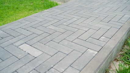 Gray tiles on the sidewalk in sunny weather. Paving stones. Concept of laying paving slabs and...