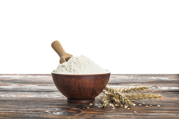 Bowl with flour, scoop and wheat ears on wooden table against white background
