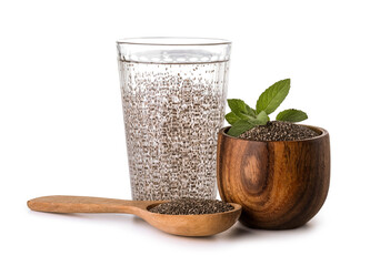 Glass of water, spoon and bowl with chia seeds on white background