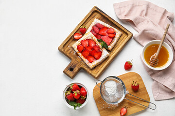 Boards with delicious puff pastry, sugar powder and bowl with honey on table