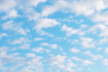White cumulus clouds in the blue sky on a clear sunny day.