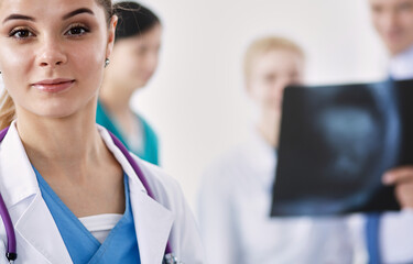 Attractive female doctor in front of medical group