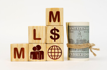 On a white surface, dollars and cubes with images and the inscription - MLM