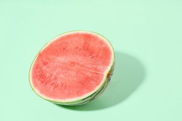 Cut watermelon on green pastel background