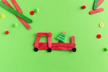 Red car with fir tree made from wooden sticks. Handmade. Project of children's creativity,...