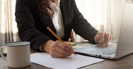 Mujer escribe una nota de una laptop