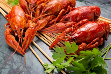 Fresh boiled red crayfish on a wooden stand with parsley. Great snack for beer.